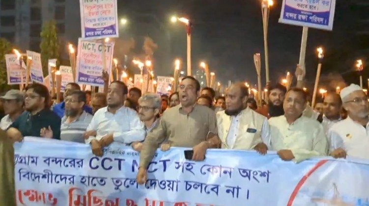 Port Protection Council Threatens Strong Action if Decision Not Withdrawn The Port Protection Council held a torch rally in protest against handing over the New Mooring Container Terminal (NCT) and Chittagong Container Terminal (CCT) to foreign companies. They warned that if the decision is not withdrawn within 40 hours, a press conference will be held on November 20 to announce a tough action plan. The rally took place on Tuesday (November 18) evening along the Port Connecting Road in the city’s Boro Pol area. Workers raised slogans such as, “My port, my mother; we won’t give it to foreigners,” “We fight to survive,” and “DP World go back.” At the subsequent gathering, Hasan Maruf Rumi, a member of the Political Council of the People’s Solidarity Movement, addressed the crowd. He said the Chittagong port was built with taxpayers’ money, yet there is a conspiracy to hand over profitable terminals to foreign companies under the guise of development. A recent report shows that the port’s revenue has increased by 21 percent. He emphasized that foreign trainers can be brought in to improve efficiency, but the government has no right to lease the country’s assets under the pretext of efficiency. Rumi also stated that although an interim government was formed for justice, reform, and elections, no real reform has been seen. Handing over NCT and CCT to foreigners would ignite protests across Chittagong and the country. Any contract against national interest will not be accepted by the people. Speakers added that NCT and CCT are self-sufficient and profitable terminals that do not require foreign investment. Leasing such terminals abroad would result in the country’s dollars leaving the economy. While foreign investment in Bay Terminal is acceptable, NCT and CCT should never be handed over to foreign companies. They warned that if the decision is not withdrawn, a strict action plan will be announced at a press conference on November 20.