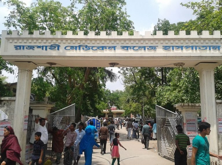 রাজশাহী মেডিকেলে অজ্ঞাত রোগে নারীর মৃত্যু রাজশাহী মেডিকেল কলেজ হাসপাতালে অজ্ঞাত রোগে এক নারীর মৃত্যু হয়েছে। হাসপাতাল কর্তৃপক্ষ এখনও নিশ্চিত করতে পারেনি, রোগটি কী ছিল। রোগতত্ত্ব, রোগনিয়ন্ত্রণ ও গবেষণাপ্রতিষ্ঠান (আইইডিসিআর) মৃত্যুর কারণ শনাক্তে অনুসন্ধান করছে। সূত্রের তথ্য অনুযায়ী, নওগাঁ জেলার এক নারী ১৪ জানুয়ারি চিকিৎসার জন্য রাজশাহী মেডিকেল কলেজ হাসপাতালে ভর্তি হন। চিকিৎসাধীন অবস্থায় ২৮ জানুয়ারি তিনি মারা যান। রোগীর স্বজনরা এখনও নিশ্চিত নন, কোন রোগে মৃত্যু হয়েছে। হাসপাতালের পরিচালক ব্রিগেডিয়ার জেনারেল পি কে এম মাসুদ উল ইসলাম মৃত্যুর কথা স্বীকার করেছেন, তবে রোগ নির্ধারণের জন্য আইইডিসিআরের সঙ্গে যোগাযোগ করার পরামর্শ দিয়েছেন। তিনি জানান, “আইইডিসিআর নমুনা নিয়ে গেছে। তারা জানাতে পারবেন কী রোগে মৃত্যু হয়েছে।” বছরের এই সময় নিপাহ ভাইরাসের ঝুঁকি থাকে। বাদুড় নিপাহ ভাইরাস বহন করে, বাদুড় খেজুরের রস খেলে ভাইরাস ছড়াতে পারে। কাঁচা রস ও বাদুড়ের খাওয়া ফল না খাওয়ার জন্য জনস্বাস্থ্য বিশেষজ্ঞরা সতর্ক করে আসছেন। দেশের বিভিন্ন জেলায় নিয়মিতভাবে নিপাহ সংক্রমণ দেখা যাচ্ছে। নওগাঁয় সংক্রমণের হার তুলনামূলকভাবে বেশি। নিপাহে মৃত্যুহারও বেশি; একশ জন আক্রান্ত হলে ৭০ জনের বেশি মারা যেতে পারে। তবে অতি সম্প্রতি আইইডিসিআর নওগাঁসহ পাঁচ জেলার নমুনা পরীক্ষা করেছে, যেগুলিতে নিপাহ শনাক্ত হয়নি। আইইডিসিআরের পরিচালক অধ্যাপক তাহমিনা শিরীন বলেন, “অনুসন্ধান চলছেই। ফলাফল না আসা পর্যন্ত মৃত্যুর কারণ বলা সম্ভব নয়।” নওগাঁ জেলার সিভিল সার্জন আমিনুল ইসলামও জানান, নারীর মৃত্যু সম্পর্কে জানেন, তবে রোগ নির্ধারণে আইইডিসিআরের অনুসন্ধান দল নওগাঁ যাচ্ছেন।